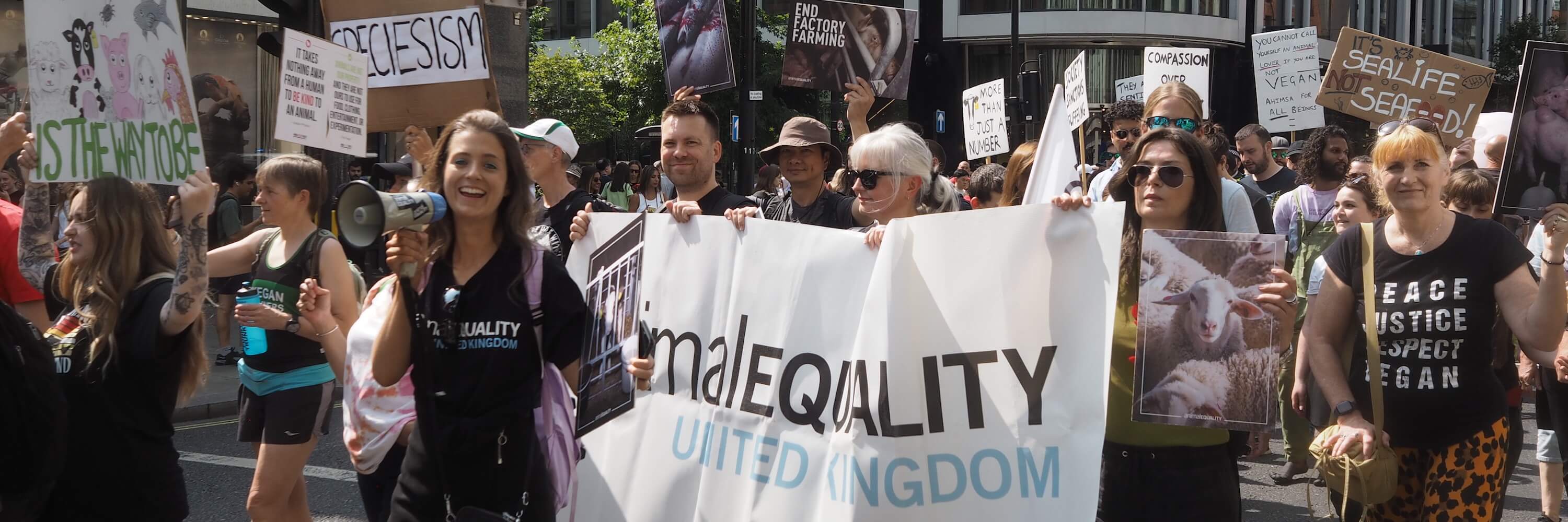 Group of people marching behind a banner that says Animal Equality at National Animal Rights March 2024 in London, UK